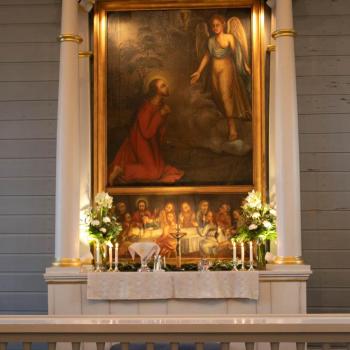 Alttari koristeltu kauniilla kukilla ja kynttilöillä